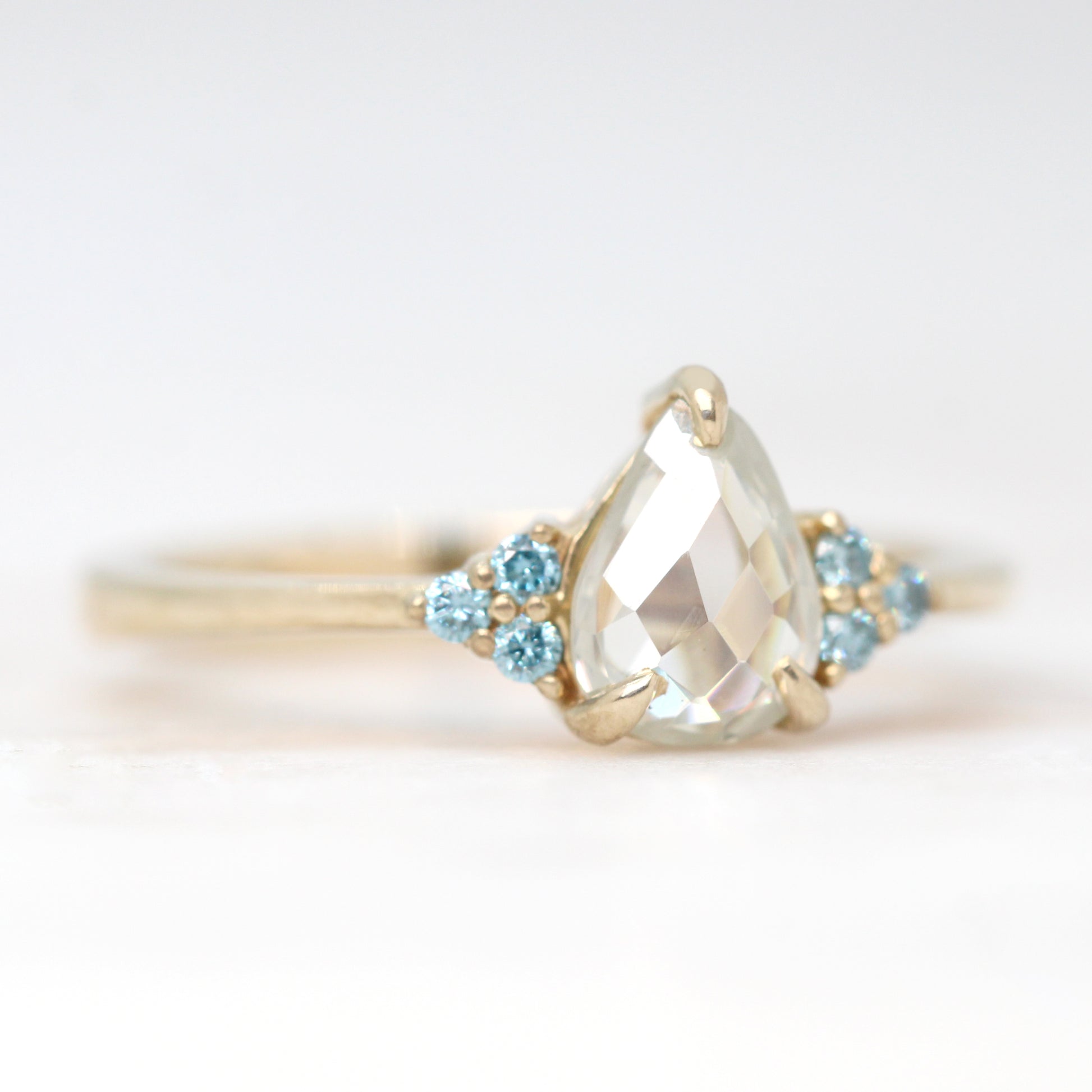 Imogene Ring with a 0.74 Carat Clear Pear Moissanite and Blue Diamond Accents in 14k Yellow Gold - Ready to Size and Ship - Midwinter Co. Alternative Bridal Rings and Modern Fine Jewelry