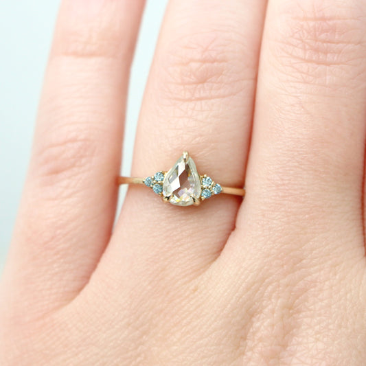 Imogene Ring with a 0.74 Carat Clear Pear Moissanite and Blue Diamond Accents in 14k Yellow Gold - Ready to Size and Ship