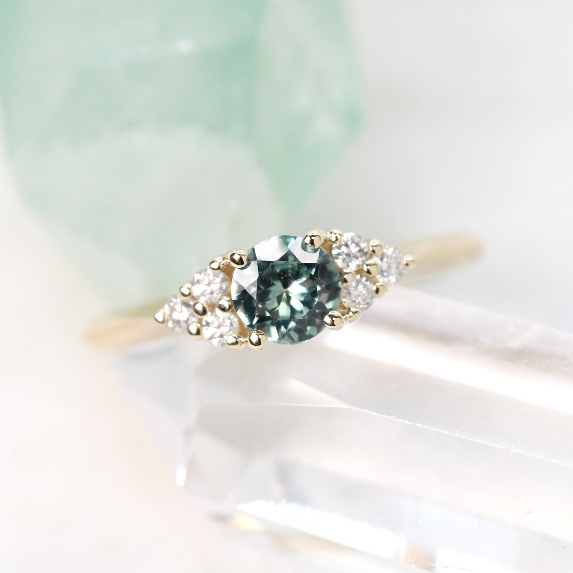 Aster Ring with a 0.57 Carat Light Teal Round Montana Sapphire and White Accent Diamonds in 14k Yellow Gold - Ready to Size and Ship - Midwinter Co. Alternative Bridal Rings and Modern Fine Jewelry