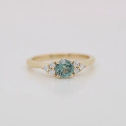 Aster Ring with a 0.57 Carat Light Teal Round Montana Sapphire and White Accent Diamonds in 14k Yellow Gold - Ready to Size and Ship
